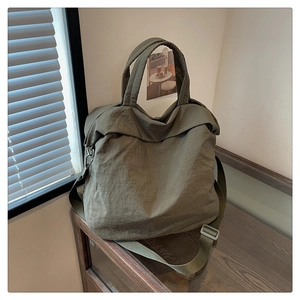 Détail d'un grand sac cabas en nylon vert armée avec texture plissée et sangle réglable