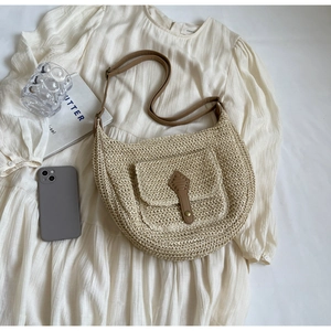 Detailansicht beige Stroh-Umhängetasche mit braunem Lederriemen und kleiner Vordertasche