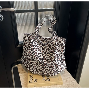 Detailed close-up of large capacity leopard print canvas tote bag on marble surface