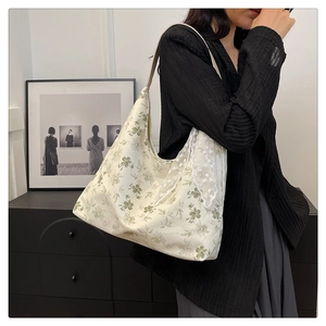 Détail du sac à épaule en toile fleurie avec bordure en dentelle blanche et motif floral
