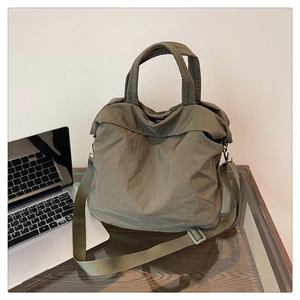 Gros plan sur le sac fourre-tout en nylon olive avec texture matelassée et bandoulière