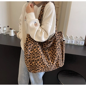 Dettaglio della borsa tote in tela leopardata con tasca laterale e tracolla larga