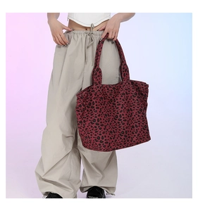 Model holding large burgundy leopard print canvas tote bag for daily fashion use