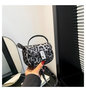 Detail of leopard print handbag featuring a silver cat silhouette metal buckle