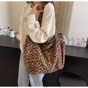 Dettaglio della borsa tote in tela leopardata con design multitasche e tracolla lunga rimovibile