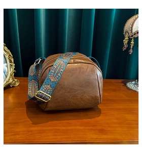 Detail der dunkelbraunen Muscheltasche mit Boho-Gurt vor einem Vintage-Samthintergrund