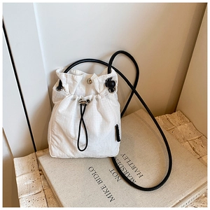 Close-up of white mini nylon bucket bag with micro-check texture and drawstring detail