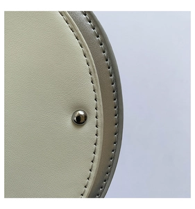 Close-up of guitar bag with pebble grain leather, white stitching and silver metal stud