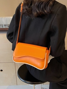 Oranje vintage crossbodytas met witte bies getoond op een vrouwelijk model