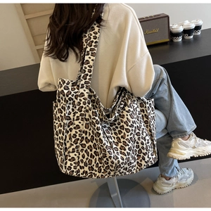 Vista dettagliata della borsa tote in tela leopardata con tasca laterale al caffè