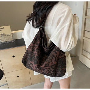Detailed back view of a large leopard print canvas tote bag carried over the shoulder