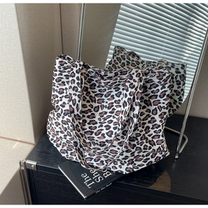 Detailed view of leopard print tote bag with soft lighting on an elegant desk