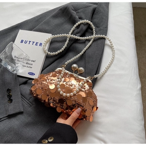 Detail of rose gold sequin evening bag with large pearl clasp and pearl chain strap