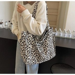 Dettaglio laterale della borsa tote in tela leopardata con pratica tasca aperta