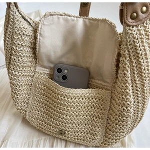 Detailansicht der Stroh-Schultertasche mit Innentasche und Magnetverschluss-Design