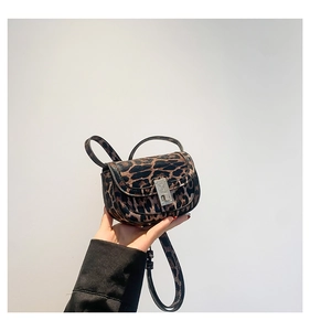 Close-up of leopard print handbag featuring a metallic silver clasp and textured PU leather