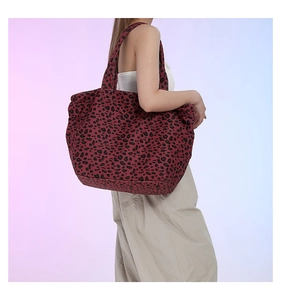 Detail of red leopard print canvas tote bag showing wide shoulder strap and large capacity