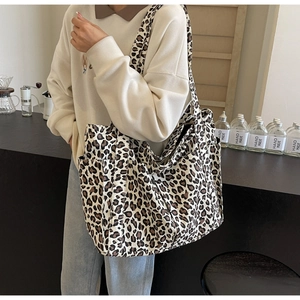 Dettaglio della borsa tote in tela leopardata con tasca laterale e tracolla lunga