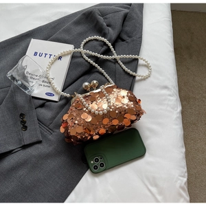 Close-up of rose gold sequin clutch bag with pearly chain and vintage metal clasp closure