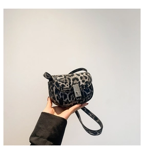 Detailed view of leopard print crossbody bag with rose engraved metal lock buckle