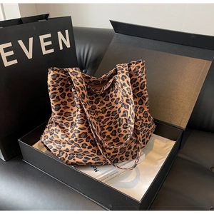 Detail view of leopard print tote bag placed in premium black gift packaging