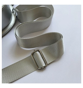 Detail of silver gray fabric shoulder strap with sleek adjustable metal buckle