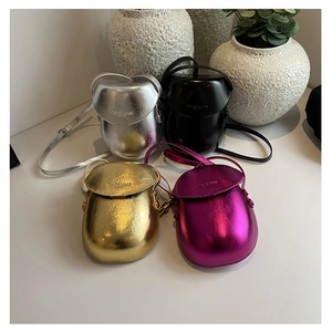 Close-up of four mini candy-colored saddle bags in metallic gold, silver, pink, and black