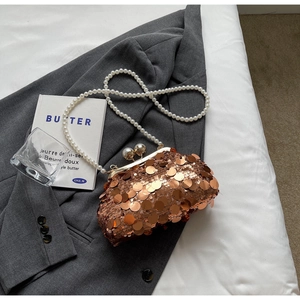 Detail of rose gold sequin evening bag with large pearl clasp and pearl chain strap