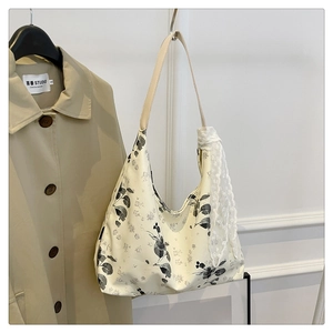 Détail du sac cabas en toile fleurie avec imprimés de plantes et ruban dentelle