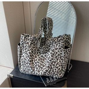 Macro della borsa tote in tela con stampa leopardata, tasche laterali e manici larghi