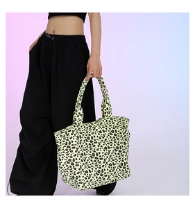 Close-up of leopard print tote bag in vibrant lime yellow with wide shoulder straps