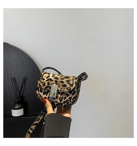 Detailed view of leopard print saddle bag with elegant silver floral buckle closure
