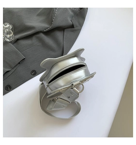 Close-up of silver guitar-shaped bag with cat ear design and metallic texture