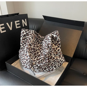 Leopard print tote bag displayed in a premium gift box with black shopping bag background