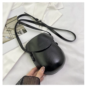 Detailed macro view of black glossy faux leather saddle bag with CLASSIC & BAG embossed logo