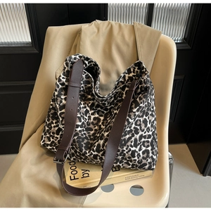 Detail of leopard print canvas tote with brown textured leather strap and large capacity