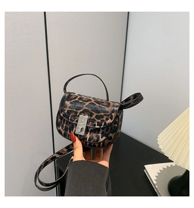 Close-up of leopard print handbag with metallic buckle and slim adjustable shoulder strap