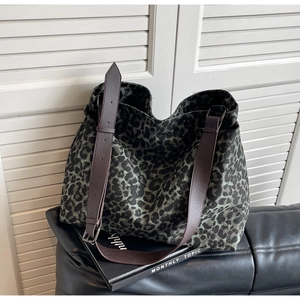 Detail of adjustable dark brown leather shoulder strap with silver metal buckle on tote bag