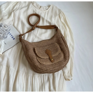 Detailstruktur der handgewebten Stroh-Hobo-Tasche mit Lederriemen und Fronttasche