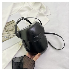 Detail of glossy black patent saddle bag featuring Fashion & Bags embossed lettering