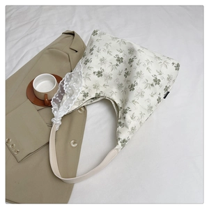 Détail du sac cabas en toile florale avec dentelle blanche délicate et motifs de fleurs printanières