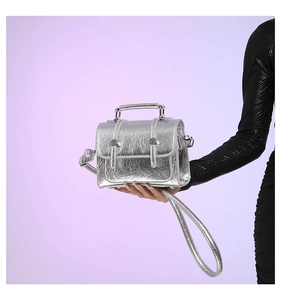 Detail of silver metallic textured crossbody bag with natural crinkle finish and top handle