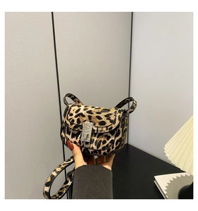 Detail of leopard print saddle bag featuring a vintage silver clasp and plush texture
