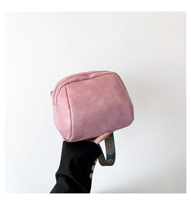 Detail der rosa strukturierten Ledertasche mit buntem geometrischem breitem Schultergurt