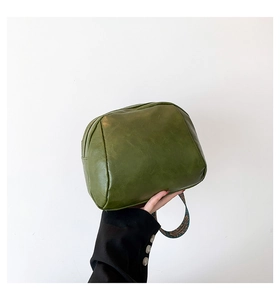 Detailansicht der grünen PU-Ledertasche mit buntem gewebtem Jacquard-Gurtband