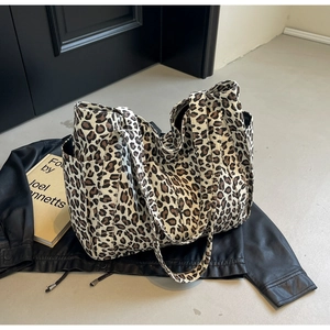 Dettaglio della borsa tote in tela leopardata con tasche laterali e trama resistente