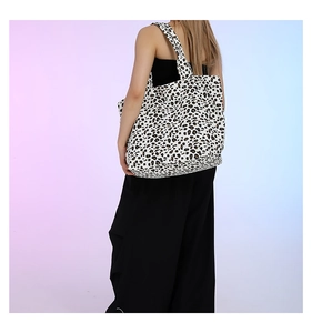 Rear view of a model carrying the large leopard print tote bag with wide straps