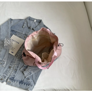 Detail of pink pleated tote bag interior with zipper pocket and drawstring closure