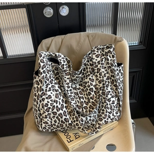Dettaglio borsa tote in tela leopardata con doppi manici e tasca laterale esterna