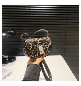Macro detail of leopard print handbag with silver metal twist-lock and engraved patterns